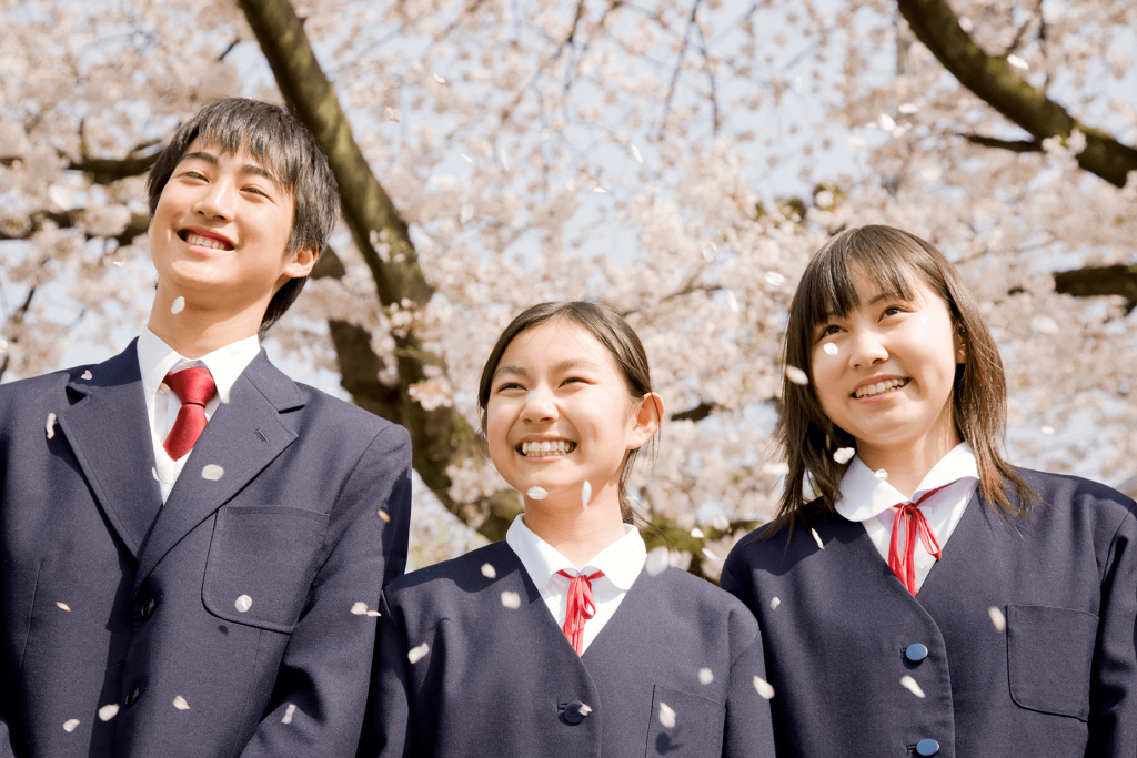 桜の木の下に並ぶ中学生