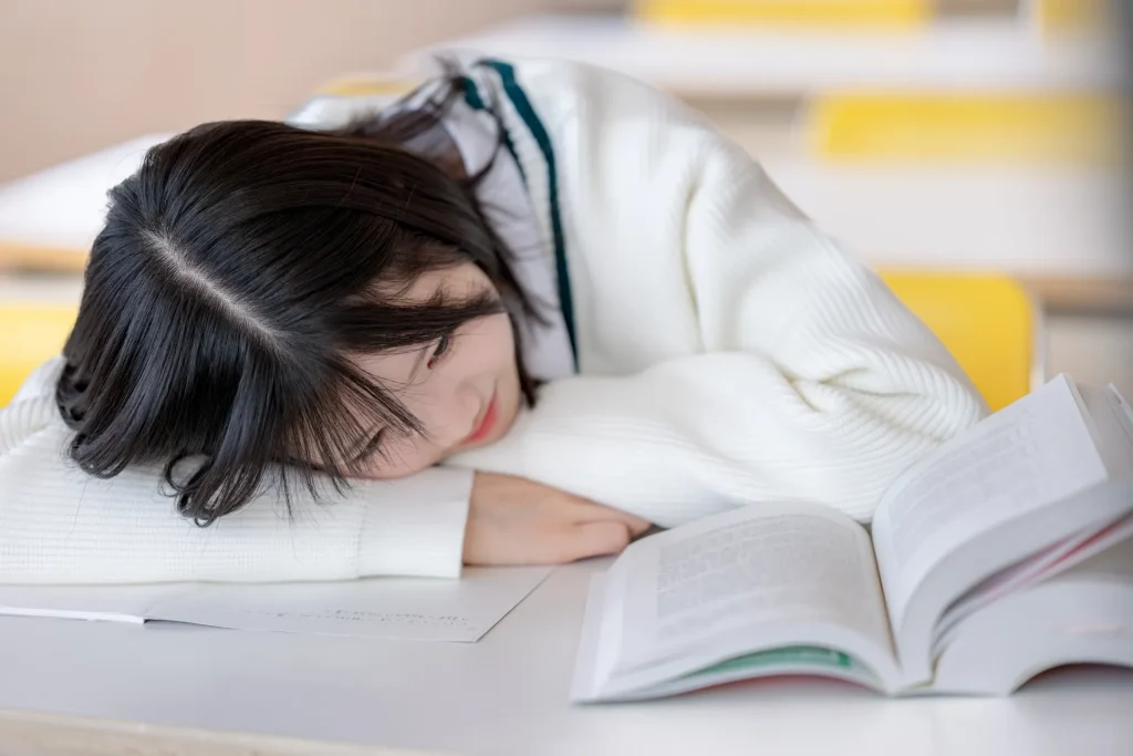 勉強に疲れて伏せている女子高生の様子